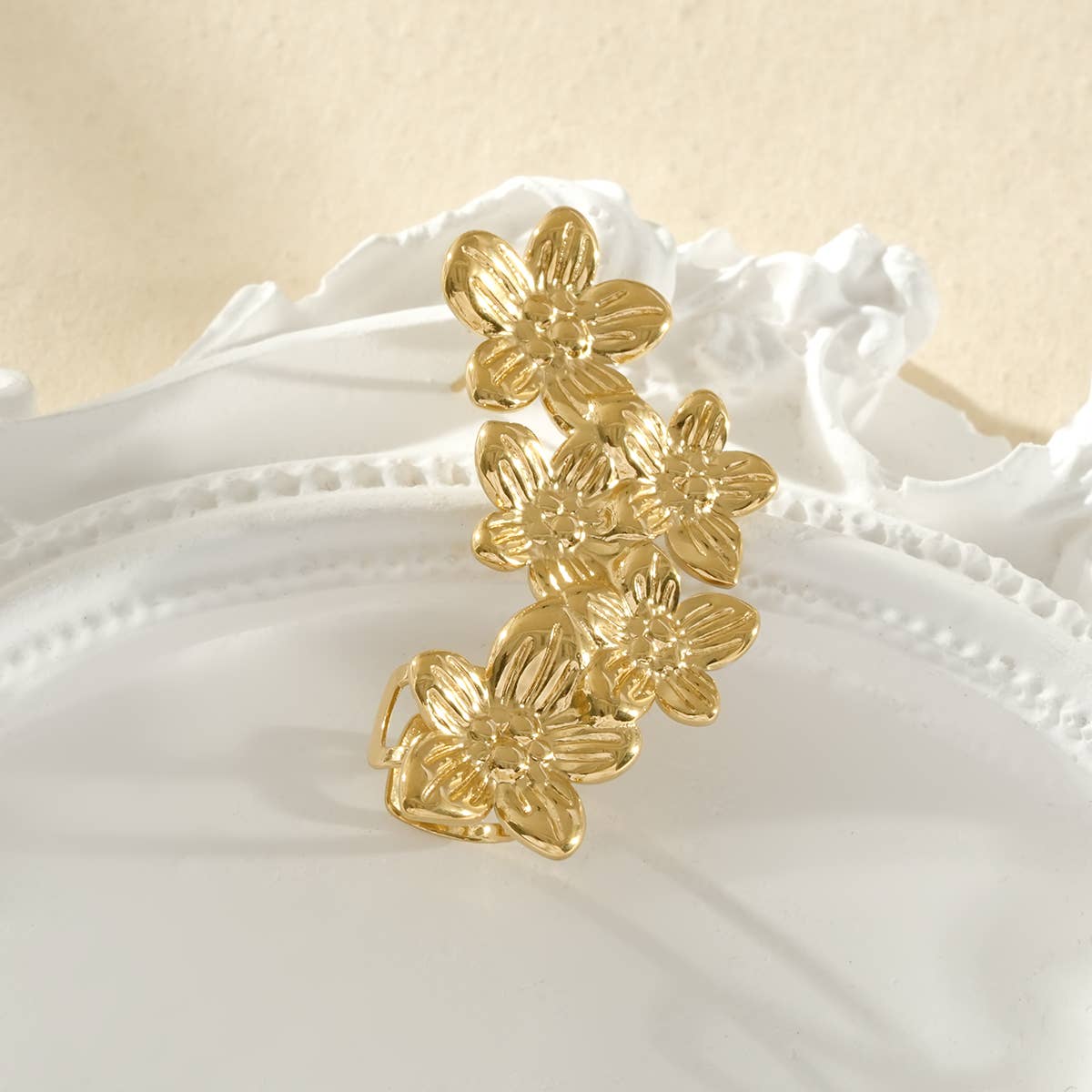 Bijou d’oreille doré avec cinq fleurs pétales côté droit