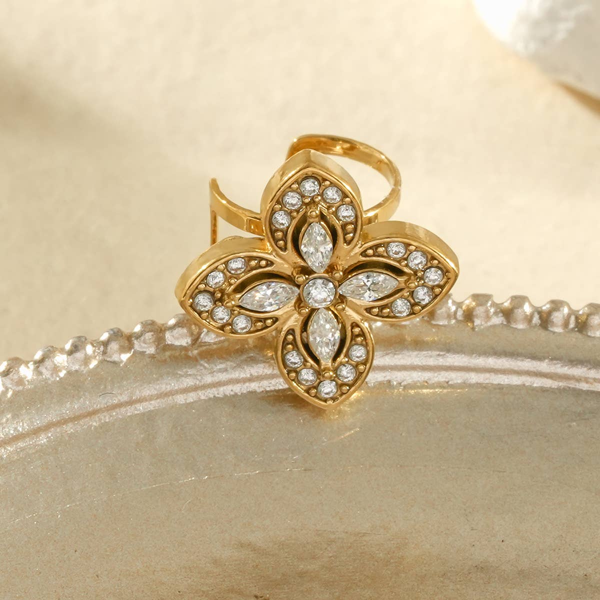 Bijou d’oreille doré à motif fleur  pavée de strass